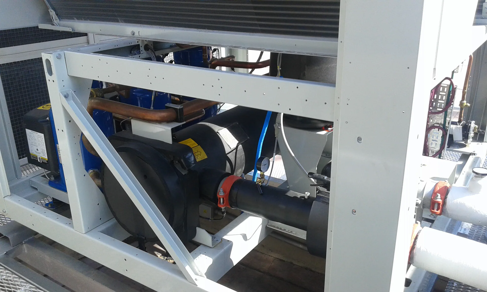 Enfriadora industrial abierta, con compresores y cañerías de refrigerante a la vista